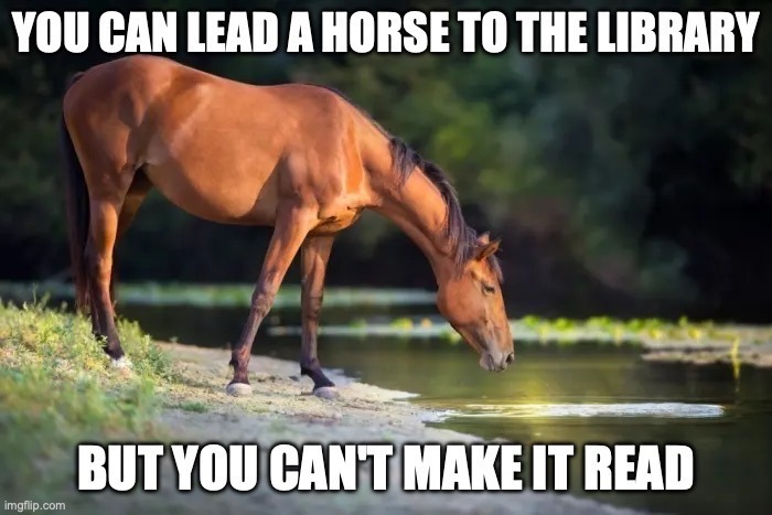 A horse standing at the edge of a river, head lowered to drink. Caption above: YOU CAN LEAD A HORSE TO THE LIBRARY. Caption below: BUT YOU CAN'T MAKE IT READ.